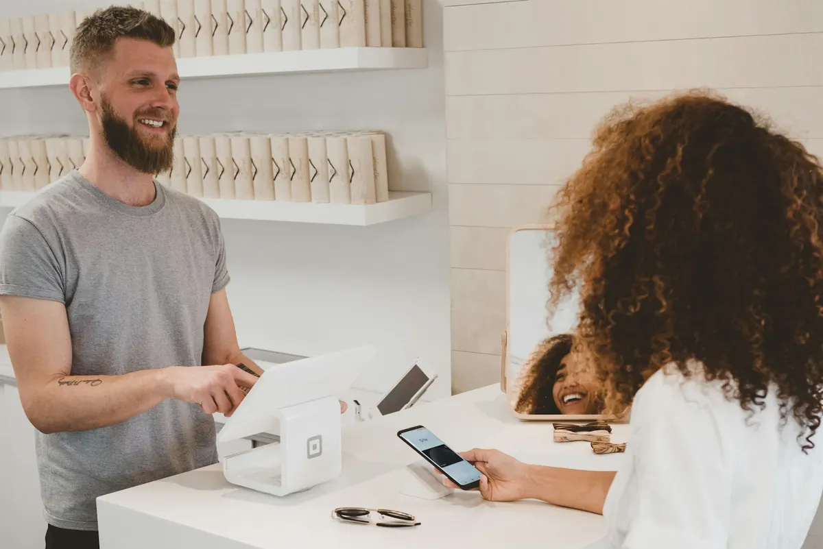 Customer paying with a phone at a shop counter